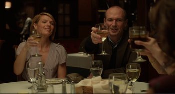 Movie still from “Enough Said” (2013), directed by Nicole Holofcener – A man and a woman sitting at a table with wine glasses; Medium shot, Low angle