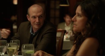 Movie still from “Enough Said” (2013), directed by Nicole Holofcener – A man and a woman sitting at a dinner table; Close Up shot, Over the shoulder angle