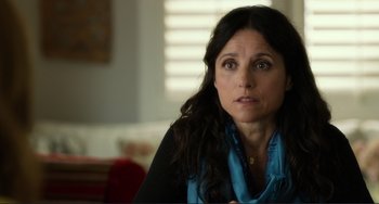 Movie still from “Enough Said” (2013), directed by Nicole Holofcener – A person sitting in a room; Close Up shot, Over the shoulder angle