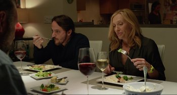 Movie still from “Enough Said” (2013), directed by Nicole Holofcener – A man and a woman sitting at a dinner table; Medium shot, Over the shoulder angle