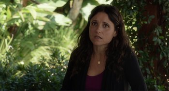 Movie still from “Enough Said” (2013), directed by Nicole Holofcener – A person wearing a jacket near a tree; Close Up shot, Over the shoulder angle