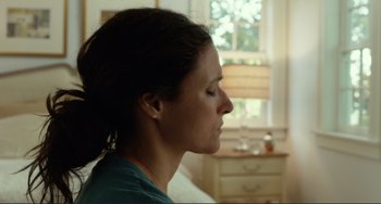 Movie still from “Enough Said” (2013), directed by Nicole Holofcener – A person with her eyes closed; Close Up shot, Over the shoulder angle