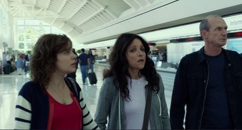 Movie still from “Enough Said” (2013), directed by Nicole Holofcener – A group of people walking in an airport terminal; Medium shot, Over the shoulder angle