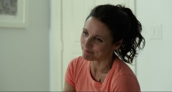 Movie still from “Enough Said” (2013), directed by Nicole Holofcener – A person sitting in front of a window; Close Up shot, Over the shoulder angle