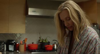 Movie still from “Enough Said” (2013), directed by Nicole Holofcener – A woman is looking down at a pot on the stove; Close Up shot, Low angle