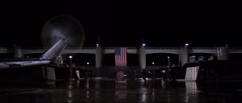 Movie still from “Escape from New York” (1981), directed by John Carpenter – A large american flag hanging in the middle of the night; Extreme Wide shot, Low angle