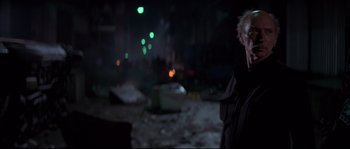Movie still from “Escape from New York” (1981), directed by John Carpenter – A man standing in the middle of an area with lights; Medium shot, Low angle