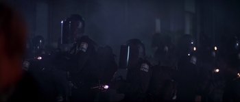 Movie still from “Escape from New York” (1981), directed by John Carpenter – A group of people in black suits and helmets; Medium shot, Low angle