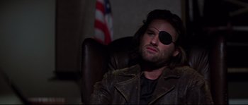 Movie still from “Escape from New York” (1981), directed by John Carpenter – A man with a eye patch sitting in a leather chair; Close Up shot, Low angle