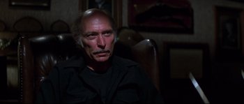 Movie still from “Escape from New York” (1981), directed by John Carpenter – A person sitting in a chair; Close Up shot, Over the shoulder angle