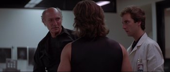 Movie still from “Escape from New York” (1981), directed by John Carpenter – An older man looking in the reflection of himself in a mirror; Medium shot, Over the shoulder angle