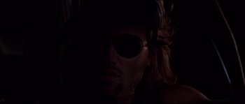Movie still from “Escape from New York” (1981), directed by John Carpenter – A person wearing a pair of sunglasses; Extreme Close Up shot, Over the shoulder angle