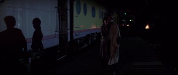 Movie still from “Escape from New York” (1981), directed by John Carpenter – A man and a woman standing in front of a train; Wide shot, Over the shoulder angle