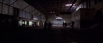 Movie still from “Escape from New York” (1981), directed by John Carpenter – A group of people walking inside of a building; Extreme Wide shot, High angle