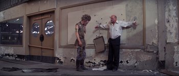 Movie still from “Escape from New York” (1981), directed by John Carpenter – A man and a woman standing in front of a wall; Wide shot, Low angle