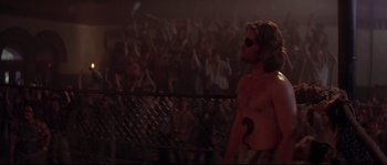 Movie still from “Escape from New York” (1981), directed by John Carpenter – A man with a blindfold is standing in front of a crowd; Medium shot, Over the shoulder angle