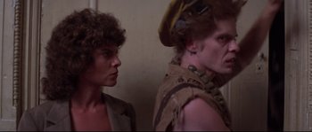 Movie still from “Escape from New York” (1981), directed by John Carpenter – A man and a woman standing next to each other in a room; Close Up shot, Low angle