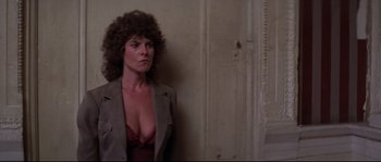 Movie still from “Escape from New York” (1981), directed by John Carpenter – A woman in a bra and jacket standing next to a wall; Close Up shot, Low angle