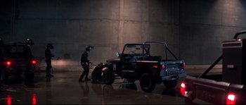 Movie still from “Escape from New York” (1981), directed by John Carpenter – A man standing next to an atv in a parking lot; Wide shot, High angle