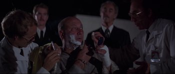Movie still from “Escape from New York” (1981), directed by John Carpenter – A man with a shaving cream on his face and another man with a shaving cream on his face and another man with a shaving cream on his face; Close Up shot, Low angle