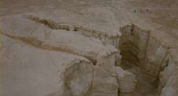 Movie still from “Essential Killing” (2010), directed by Jerzy Skolimowski – A rock formation with a person standing on top of it; Extreme Wide shot, High angle