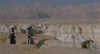 Movie still from “Essential Killing” (2010), directed by Jerzy Skolimowski – A man in a hat standing on top of a hill; Extreme Wide shot, High angle