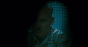 Movie still from “Essential Killing” (2010), directed by Jerzy Skolimowski – A man in a military uniform looking at the camera; Close Up shot, Over the shoulder angle