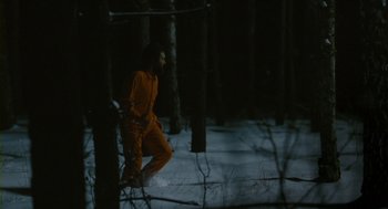 Movie still from “Essential Killing” (2010), directed by Jerzy Skolimowski – A man in a yellow suit in the woods; Extreme Wide shot, High angle