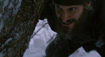 Movie still from “Essential Killing” (2010), directed by Jerzy Skolimowski – A man with a long beard and a hat is looking at the camera; Close Up shot, Low angle