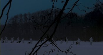 Movie still from “Essential Killing” (2010), directed by Jerzy Skolimowski – A group of people standing on top of a snow covered field; Extreme Wide shot, High angle