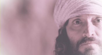 Movie still from “Essential Killing” (2010), directed by Jerzy Skolimowski – A man with long hair wearing a white turban; Extreme Close Up shot, Low angle