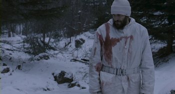 Movie still from “Essential Killing” (2010), directed by Jerzy Skolimowski – A man in a white jacket with blood on his clothes; Medium shot, High angle