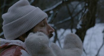 Movie still from “Essential Killing” (2010), directed by Jerzy Skolimowski – A man in a white hat and mittens; Close Up shot, Low angle