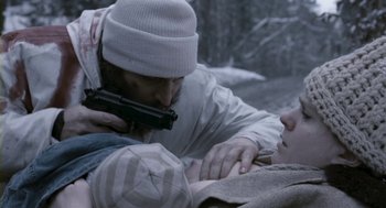 Movie still from “Essential Killing” (2010), directed by Jerzy Skolimowski – A man holding a gun over a woman's face; Close Up shot, Over the shoulder angle