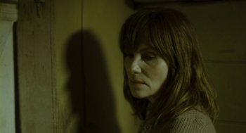 Movie still from “Essential Killing” (2010), directed by Jerzy Skolimowski – A woman with long brown hair is looking into the distance; Close Up shot, Low angle