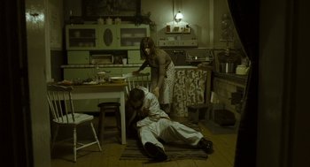 Movie still from “Essential Killing” (2010), directed by Jerzy Skolimowski – A man and a woman in a kitchen; Wide shot, High angle