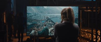 Movie still from “The Quake” (2018), directed by John Andreas Andersen – A woman standing in front of a television; Medium shot, Over the shoulder angle