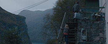 Movie still from “The Quake” (2018), directed by John Andreas Andersen – Two people climbing up the stairs to the top of a hill; Extreme Wide shot, High angle