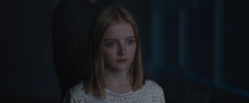 Movie still from “The Quake” (2018), directed by John Andreas Andersen – A young girl with blue eyes is staring straight ahead; Close Up shot, Over the shoulder angle