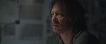 Movie still from “The Quake” (2018), directed by John Andreas Andersen – A person with long hair and a beard; Close Up shot, Over the shoulder angle