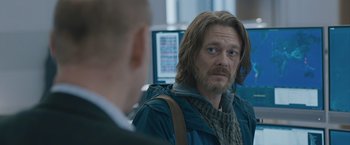 Movie still from “The Quake” (2018), directed by John Andreas Andersen – A man with long hair is looking at a computer screen; Close Up shot, Over the shoulder angle