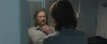 Movie still from “The Quake” (2018), directed by John Andreas Andersen – A man looking at himself in the mirror in front of a mirror; Close Up shot, Over the shoulder angle