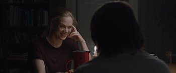 Movie still from “The Quake” (2018), directed by John Andreas Andersen – A woman sitting in front of a mirror holding a cup; Medium shot, Over the shoulder angle