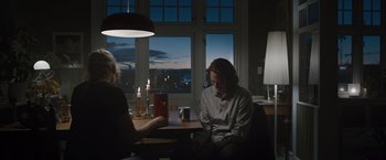 Movie still from “The Quake” (2018), directed by John Andreas Andersen – A man and woman sitting at a table in front of a window; Medium shot, Low angle