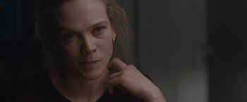 Movie still from “The Quake” (2018), directed by John Andreas Andersen – A person wearing a black shirt; Close Up shot, Over the shoulder angle