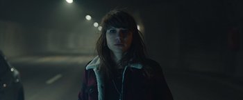 Movie still from “The Quake” (2018), directed by John Andreas Andersen – A woman in a black jacket is standing in a dark room; Close Up shot, Low angle