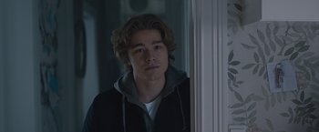 Movie still from “The Quake” (2018), directed by John Andreas Andersen – A young man looking out of a window at the camera; Close Up shot, Over the shoulder angle