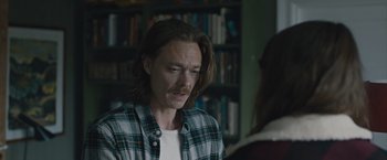 Movie still from “The Quake” (2018), directed by John Andreas Andersen – A man with long brown hair and a plaid shirt; Close Up shot, Over the shoulder angle