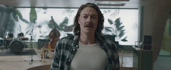 Movie still from “The Quake” (2018), directed by John Andreas Andersen – A man with long hair and a mustache is looking at the camera; Medium shot, Low angle