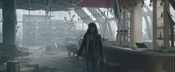 Movie still from “The Quake” (2018), directed by John Andreas Andersen – A woman standing in an empty restaurant with lights in the background; Wide shot, Over the shoulder angle